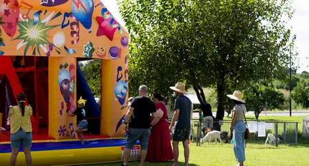 Jumping castle on the lawn, families watching