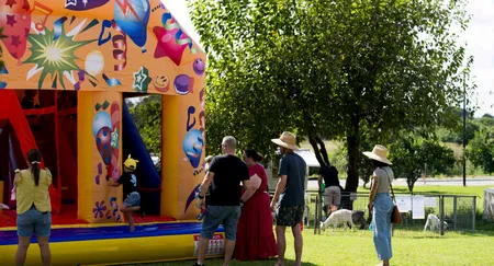 Jumping castle on the lawn, families watching